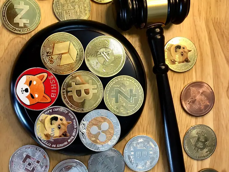 A judge's gavel resting among cryptocurrency coins